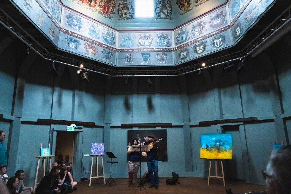 Interior view of a beautiful blue domed room with artwork and two musicians