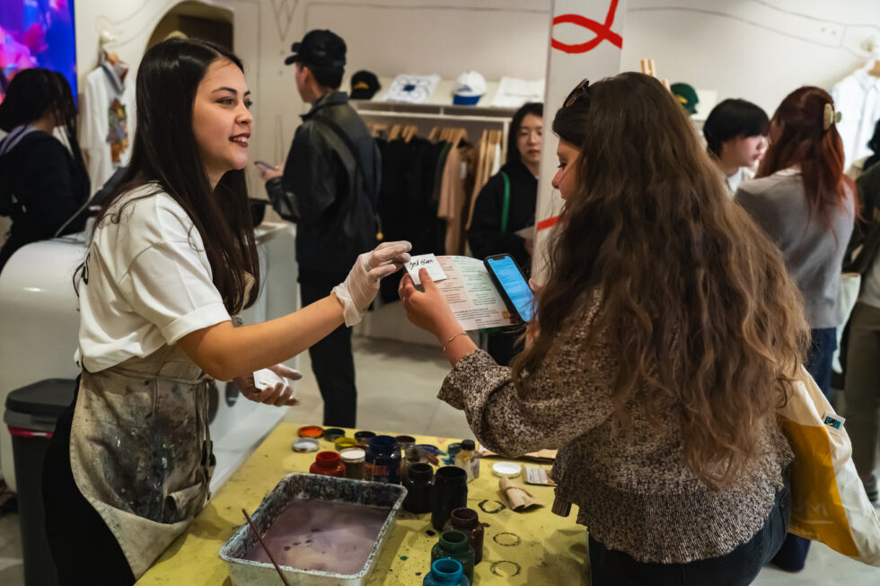 Woman interacting with artist and Pop-In Day flyer