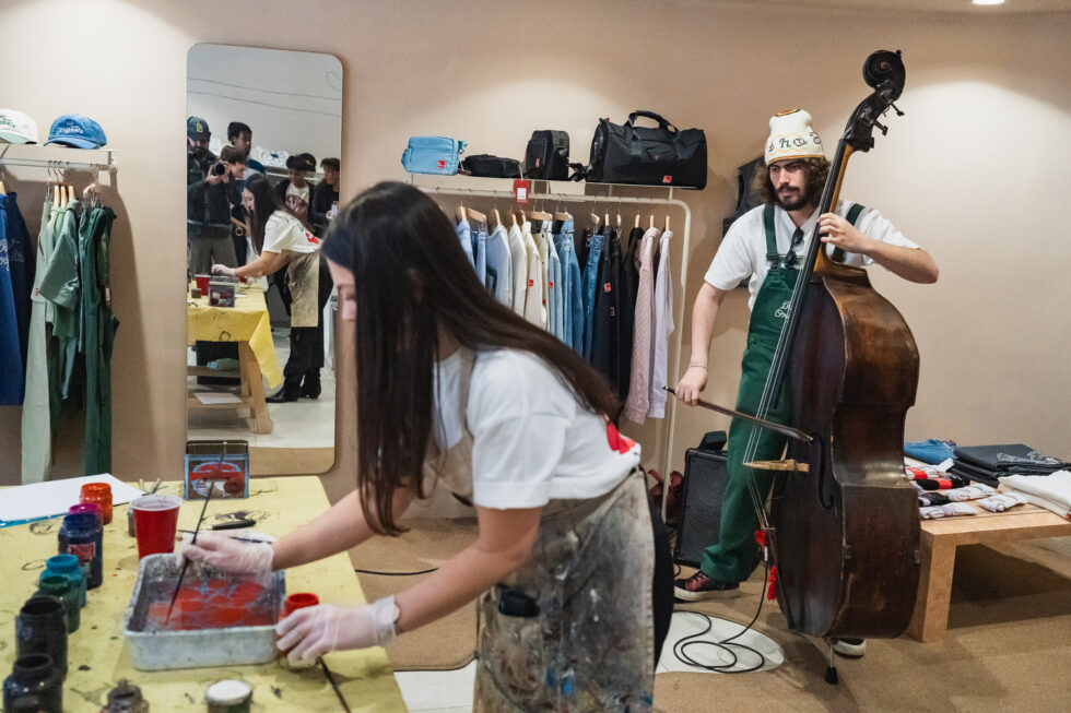 Artist working with paints, musician with a double bass in a creative studio or shop.