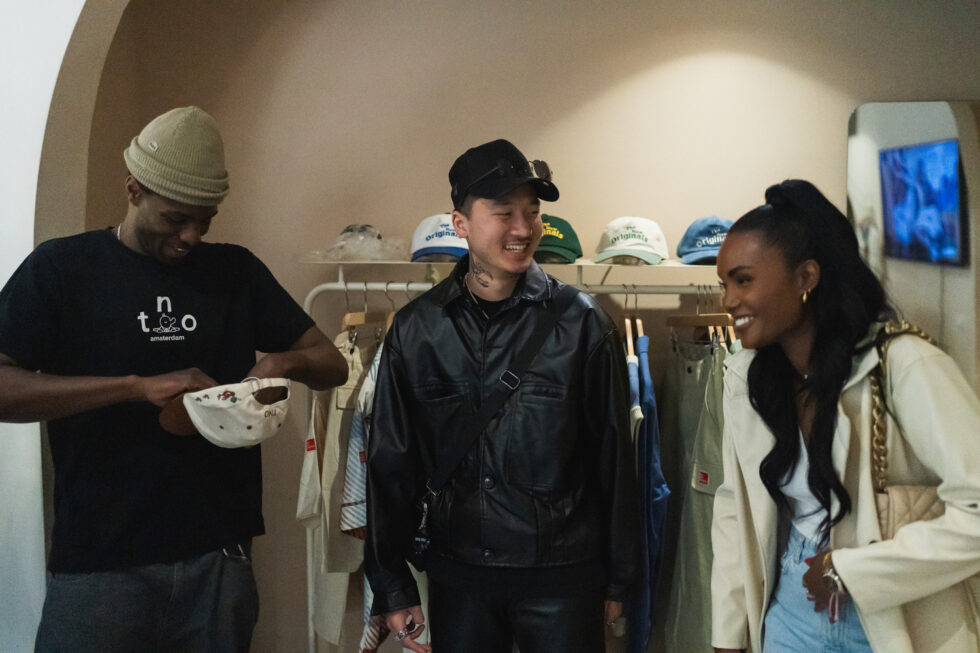 3 people smiling and laughing in the clothing store.