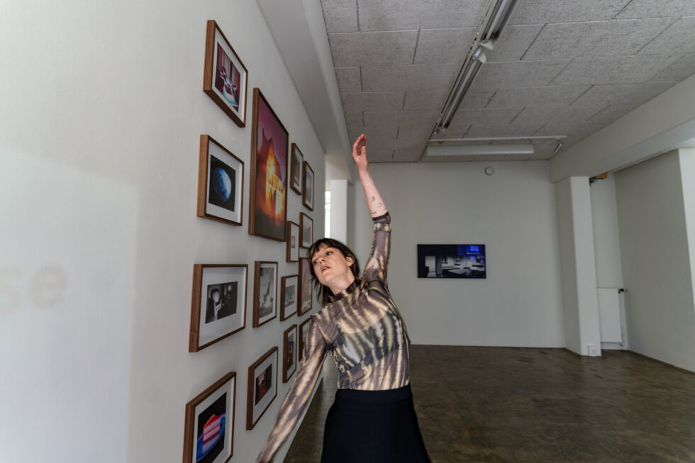 Woman gazing upwards in art gallery with framed photos on wall