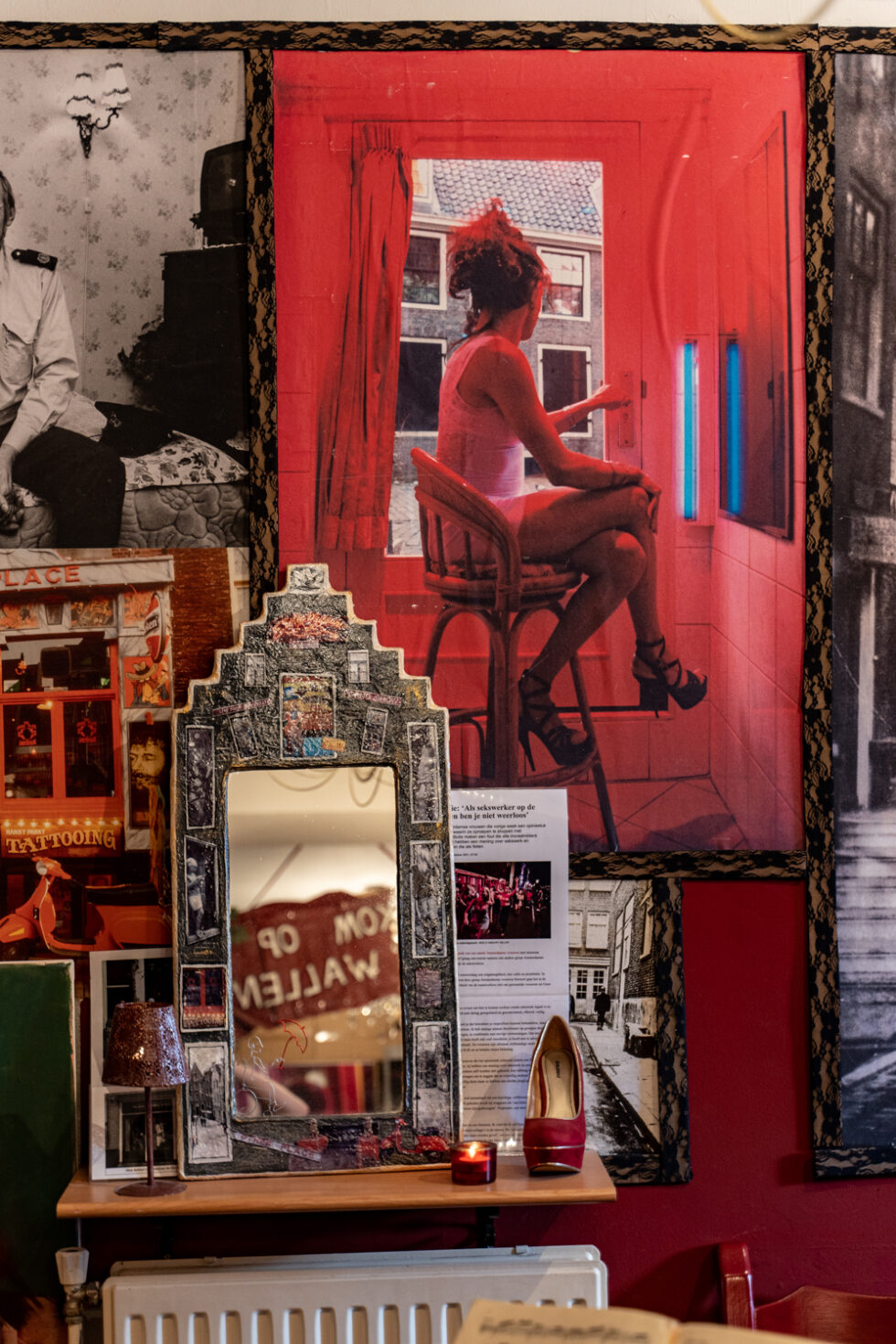 Red light district decor with mirror and poster of woman in window.