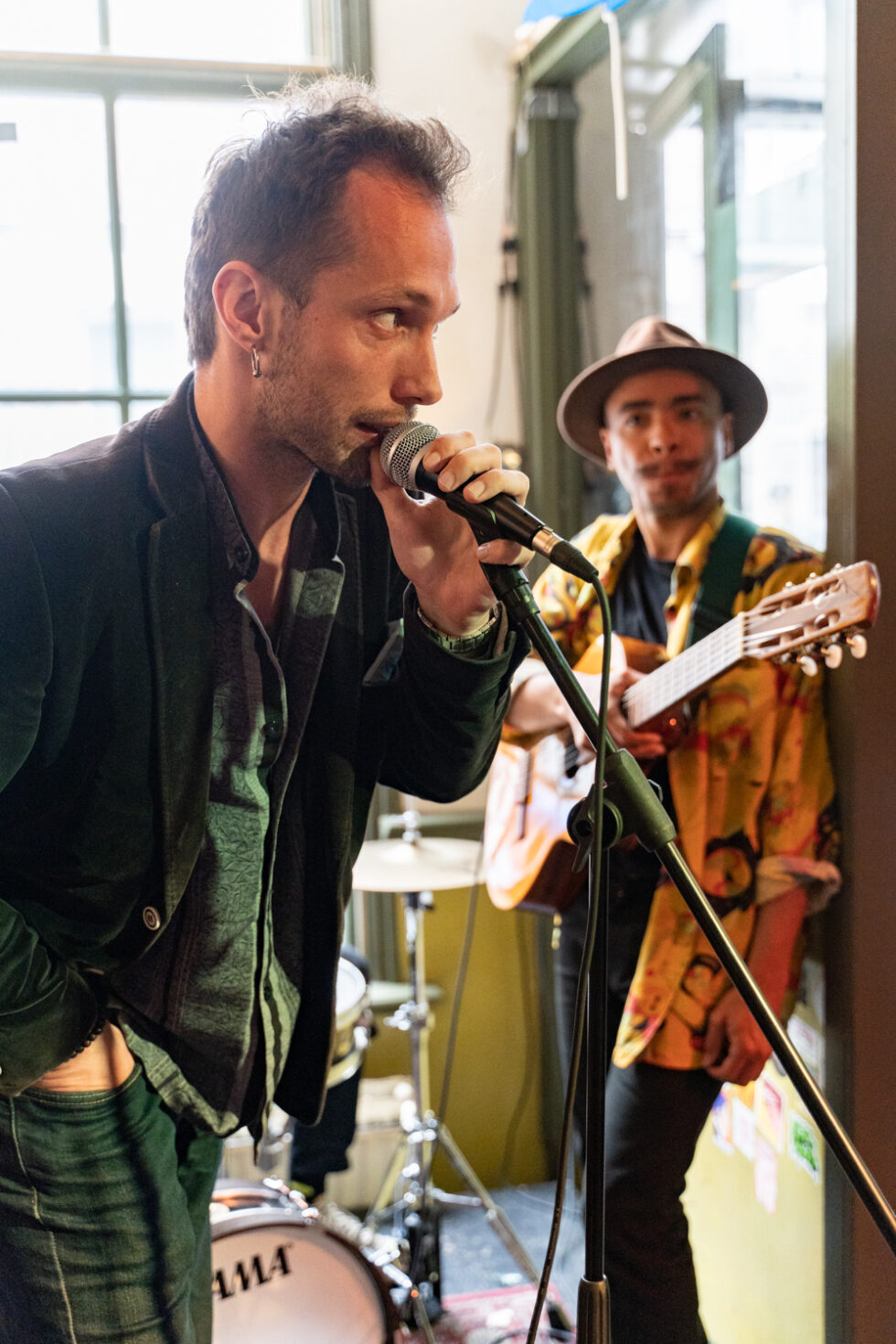 Announcer at microphone with guitarist in background